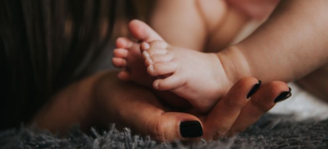 Mujer sosteniendo pies de bebés