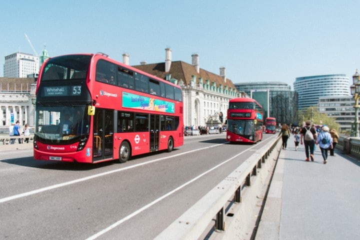 Autobuses de Londres en una calle. Una forma de ganar dinero en Airbnb sin tener una propiedad es ofreciendo visitas guiadas a su ciudad en Airbnb Experiences.