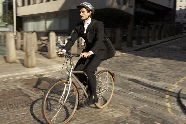 Un hombre viaja al trabajo en bicicleta.